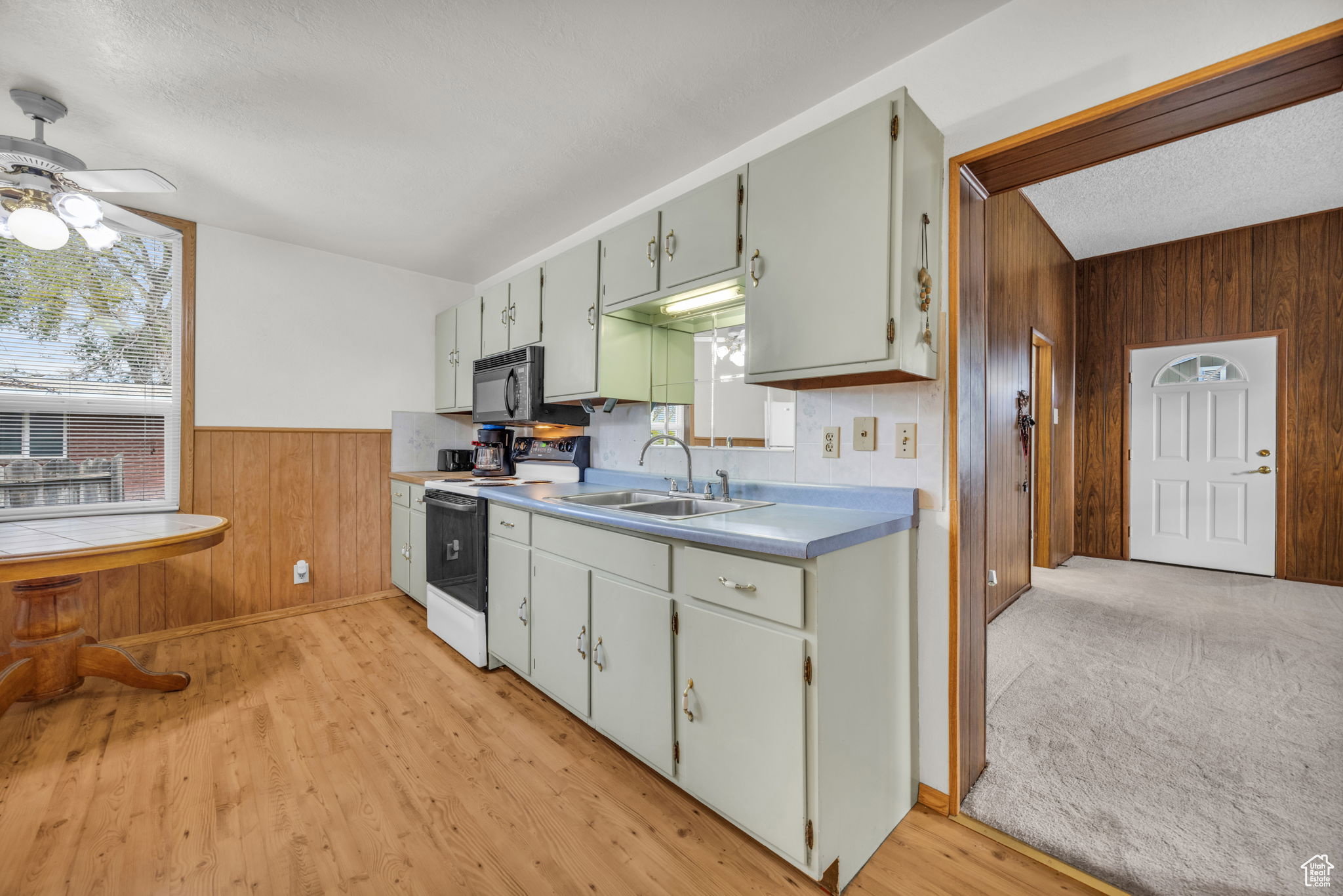 Kitchen featuring wood-finish flooring, light blue countertops, and white cabinetry