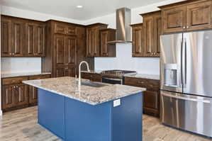 Kitchen featuring wood cabinetry, stainless steel appliances, a center island with a sink, granite countertops, and wood-finish flooring