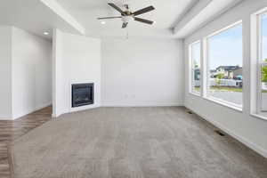 Spacious interior featuring a contemporary fireplace, tray ceiling, and multiple large windows