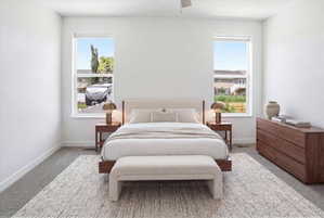 Bright bedroom featuring two large windows, white walls, and gray carpet