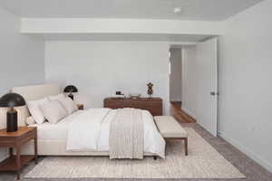 Bedroom featuring a neutral color palette, plush carpeting, wood-finish flooring visible from the doorway, and a crisp white door