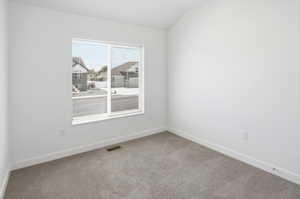 Bright interior space featuring a large window with blinds, light gray carpet, white baseboards, and white painted walls
