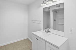 Bathroom featuring a contemporary vanity with white cabinetry, a single basin sink, and a white countertop