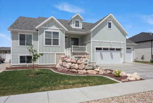 Contemporary residence featuring light green siding and a grey shingle roof