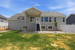 Spacious backyard featuring a manicured lawn, gravel landscaping, and a covered patio