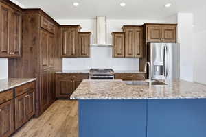 Modern kitchen featuring a contrasting blue island base, granite countertops, and wood-finish flooring