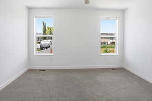Neutral-toned wall-to-wall carpeting complements clean white walls