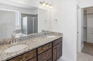 Double vanity featuring undermount sinks and a speckled stone countertop