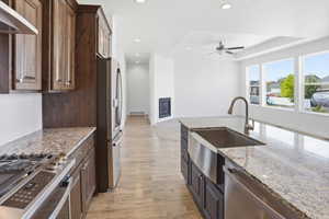 Kitchen island with granite countertop, stainless steel farmhouse sink, and gooseneck faucet