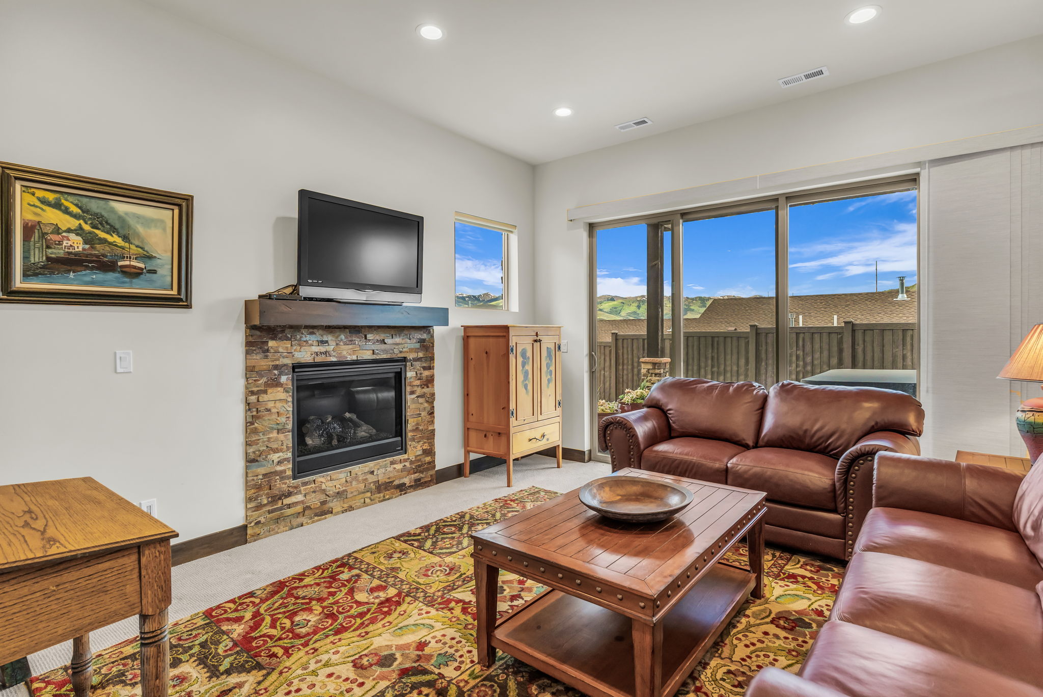 Living area with a stone-clad fireplace and a wood mantel