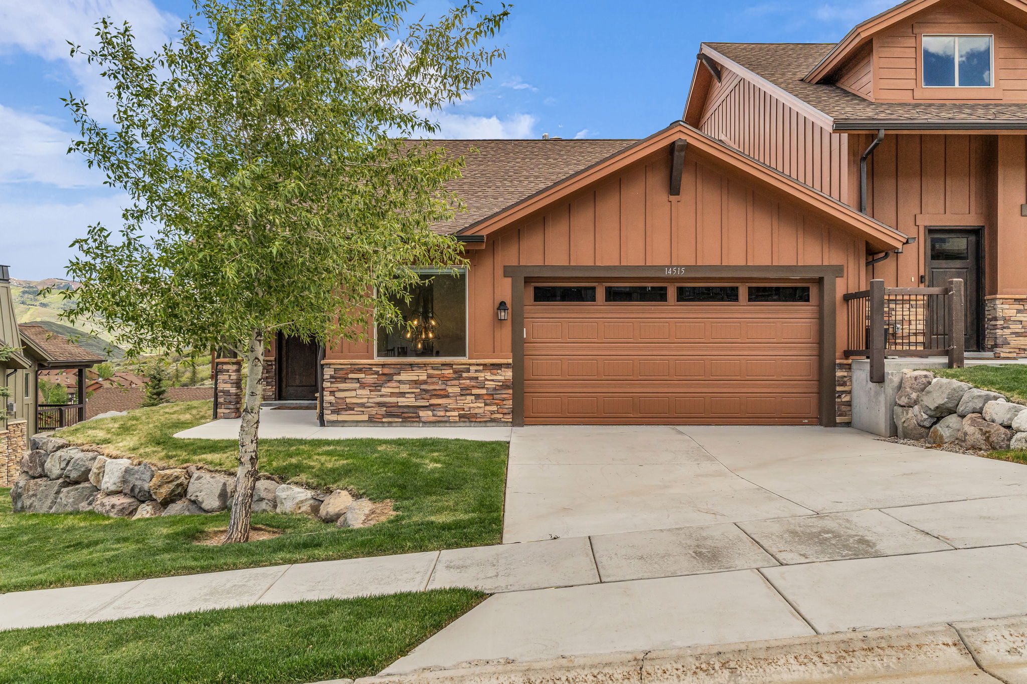 Craftsman-style home featuring a two-car garage, stone façade accents, and a covered entry