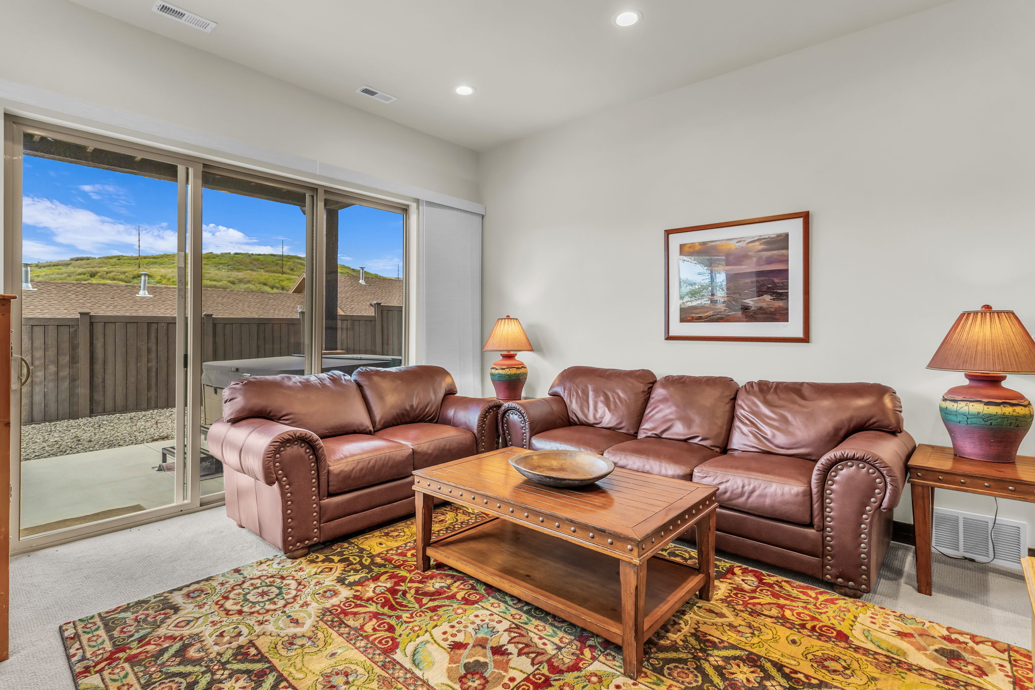 Spacious living area featuring large sliding glass doors, recessed lighting, and light-colored walls