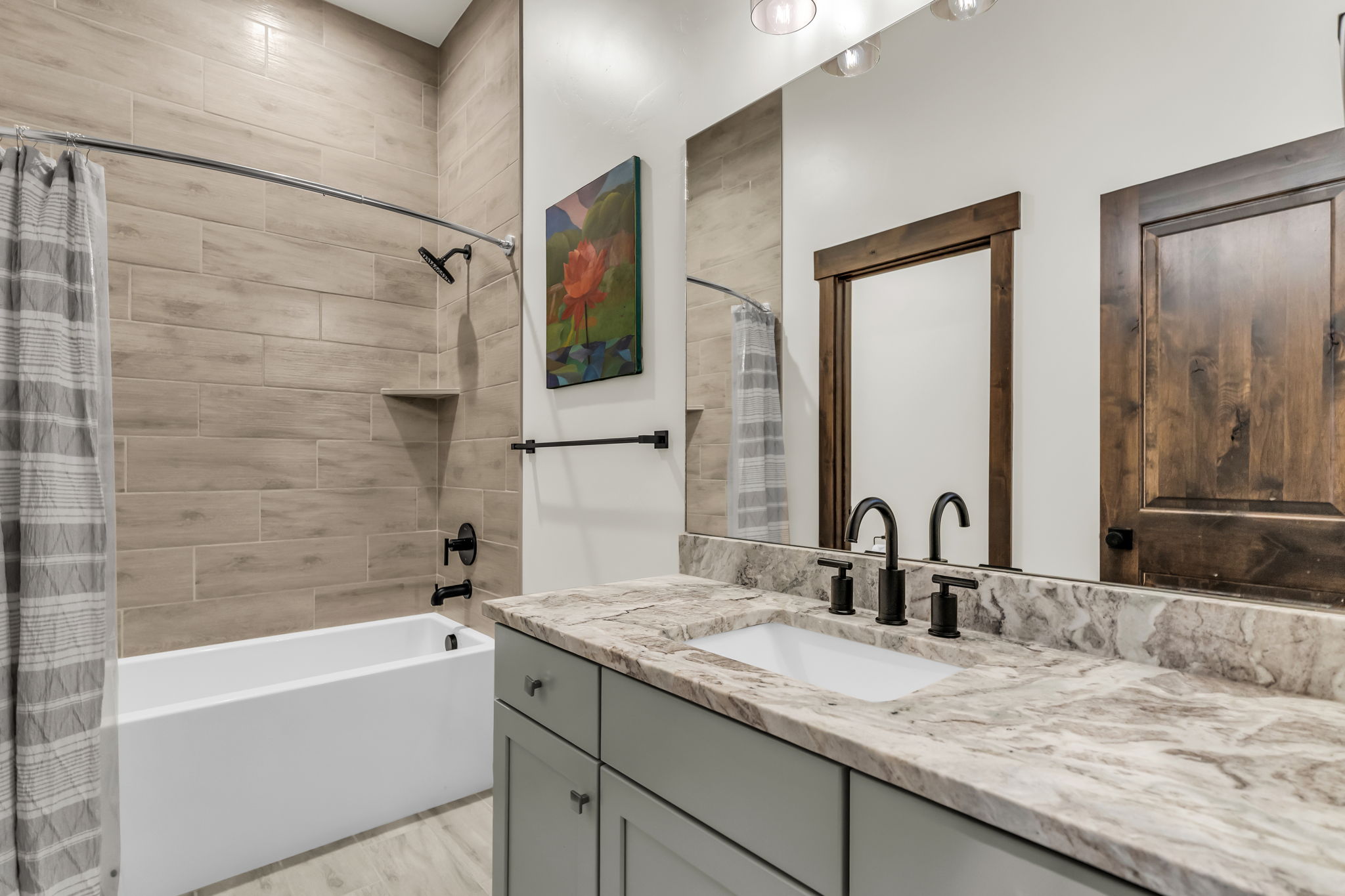 Bathroom featuring a white bathtub with wood-look tile surround and a built-in shower niche