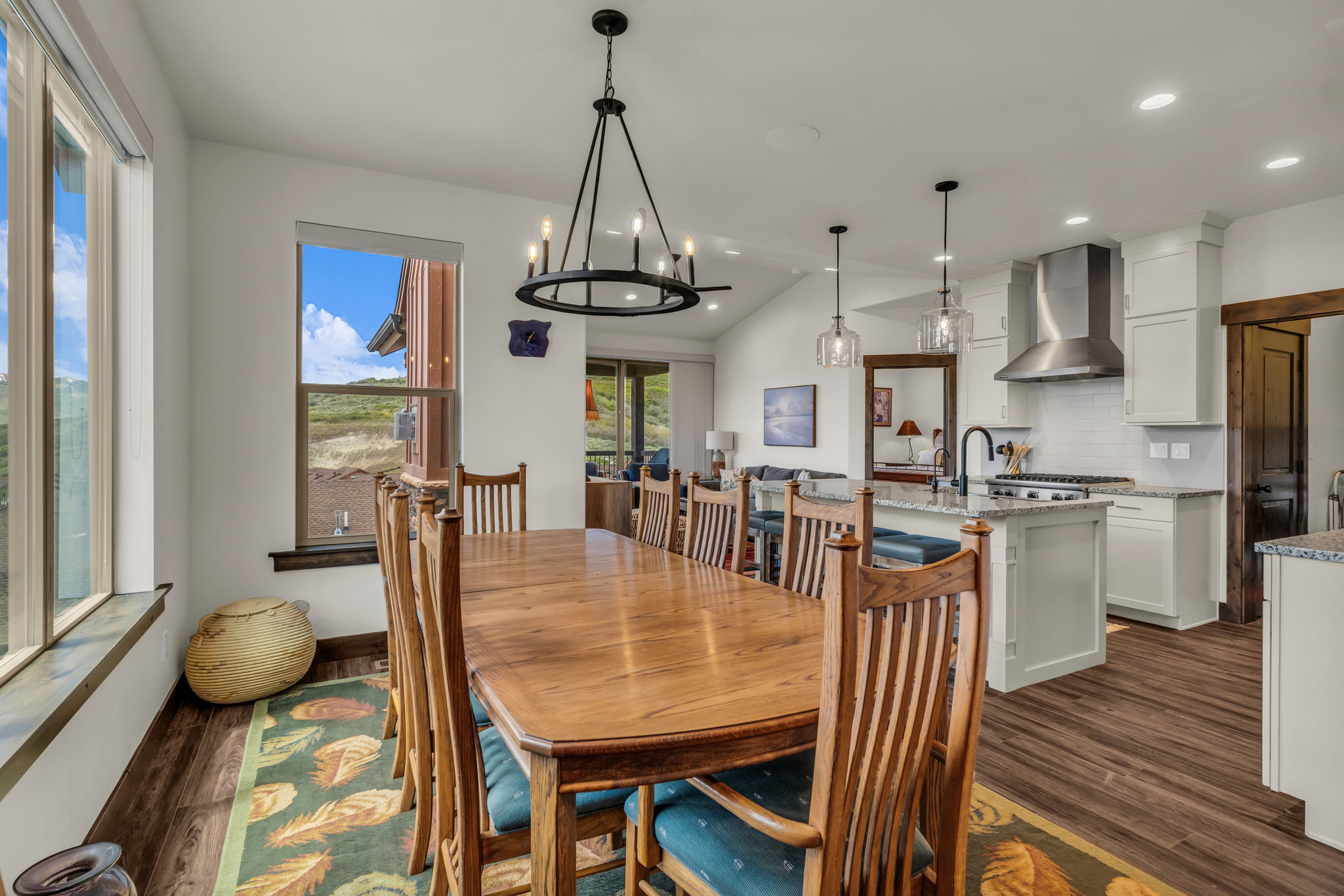Dining area featuring wood-finish flooring, a contemporary chandelier, and multiple windows