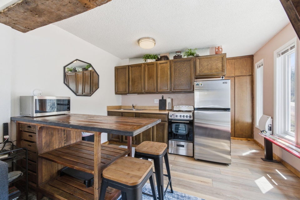 Compact kitchen featuring wood-finish flooring and upper cabinetry