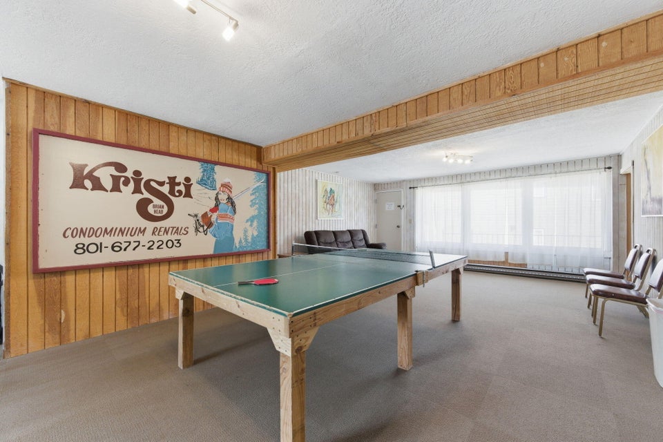 Recreation room featuring wood paneling, track lighting, and a wall of windows
