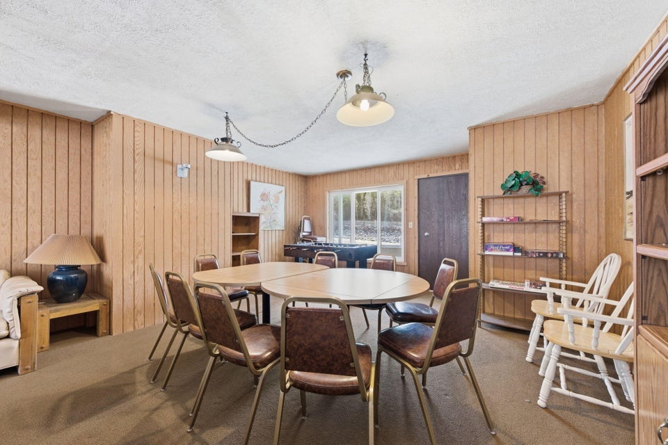 Recreation room featuring wood-panel walls and carpet flooring