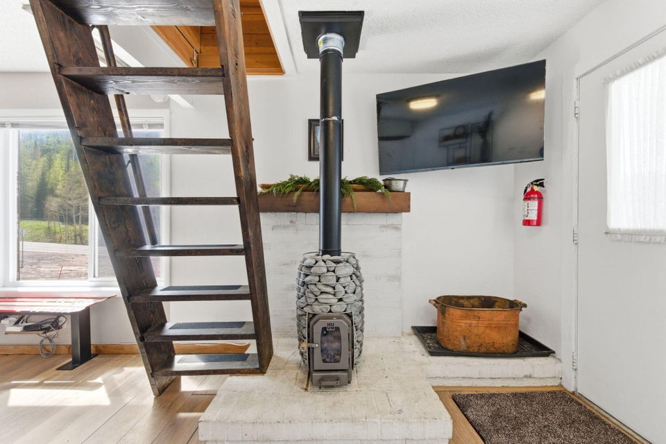 Freestanding wood-burning stove with a stacked stone base and brick hearth