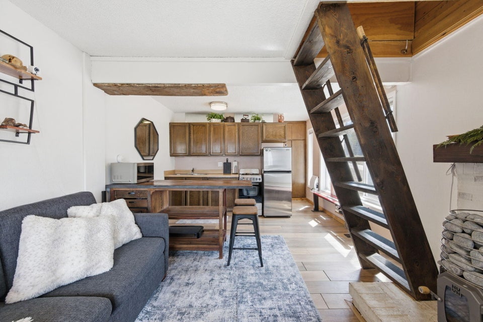 Bright interior featuring a kitchen with wood cabinetry, stainless steel appliances, and a wood-finish countertop