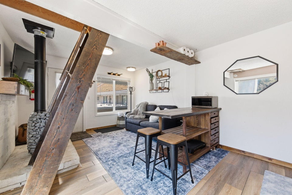 Living area featuring a wood-finish flooring, white walls, and recessed lighting