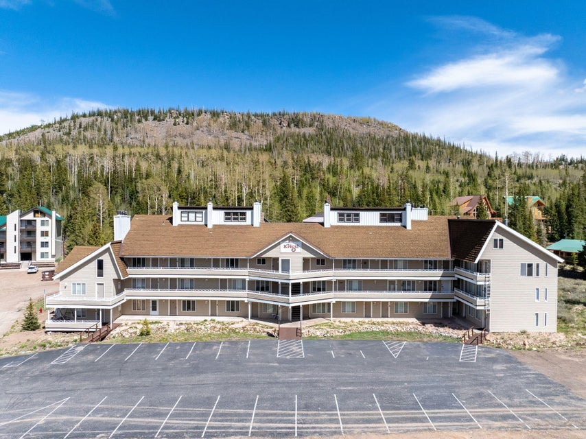 Multi-level building featuring a brown shingle roof, light-toned siding, and multiple private balconies