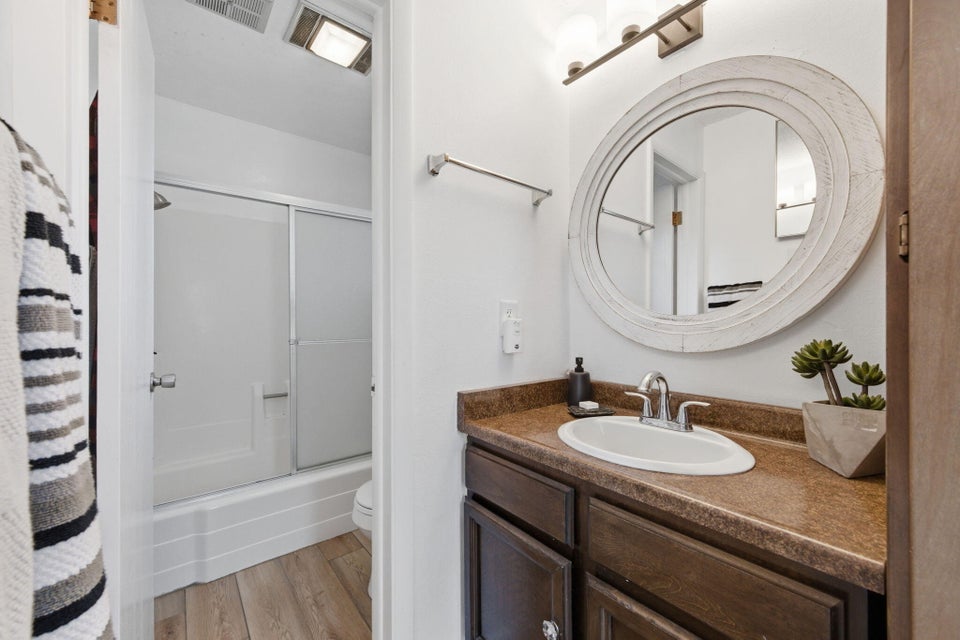 Bathroom featuring a wood-finish vanity with a built-in sink and brown countertop