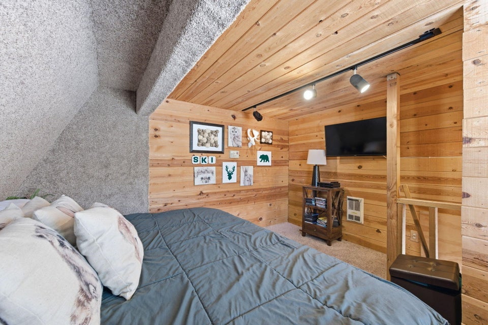 Slanted ceiling with textured gray finish and wood-paneled walls