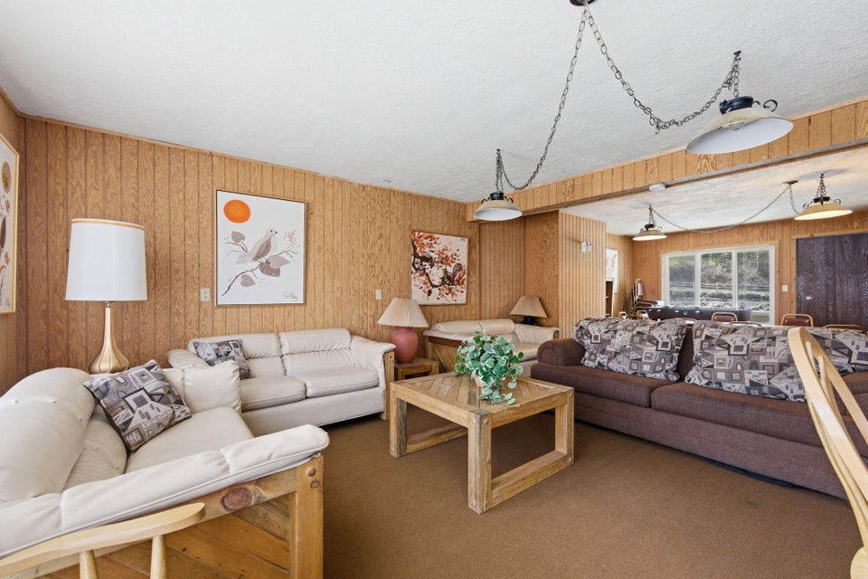 Room featuring wood paneling, a neutral-toned ceiling, and carpet flooring