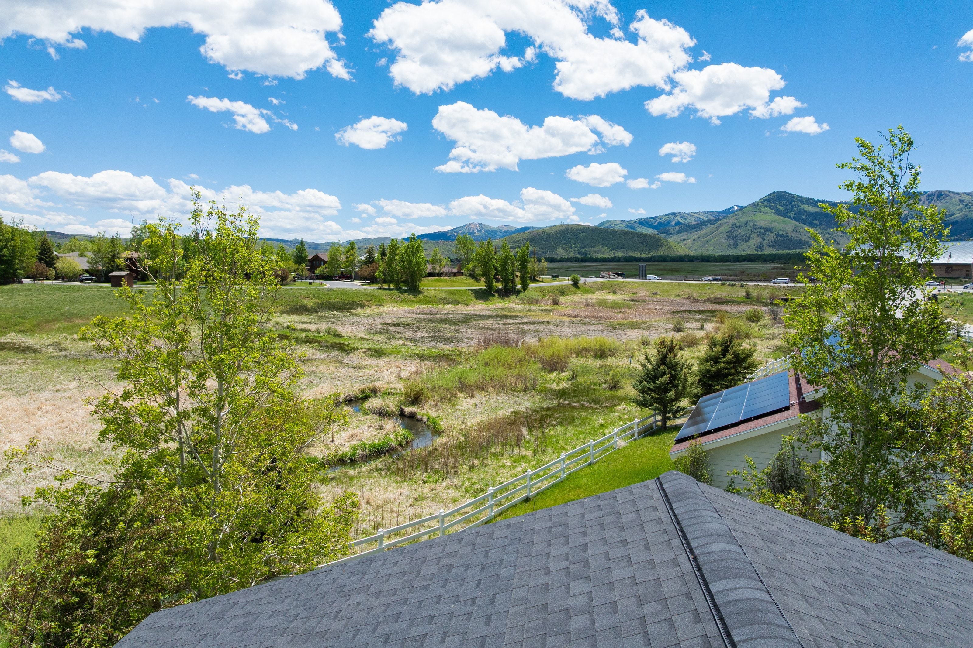 Expansive natural landscape with a meandering stream and distant mountains