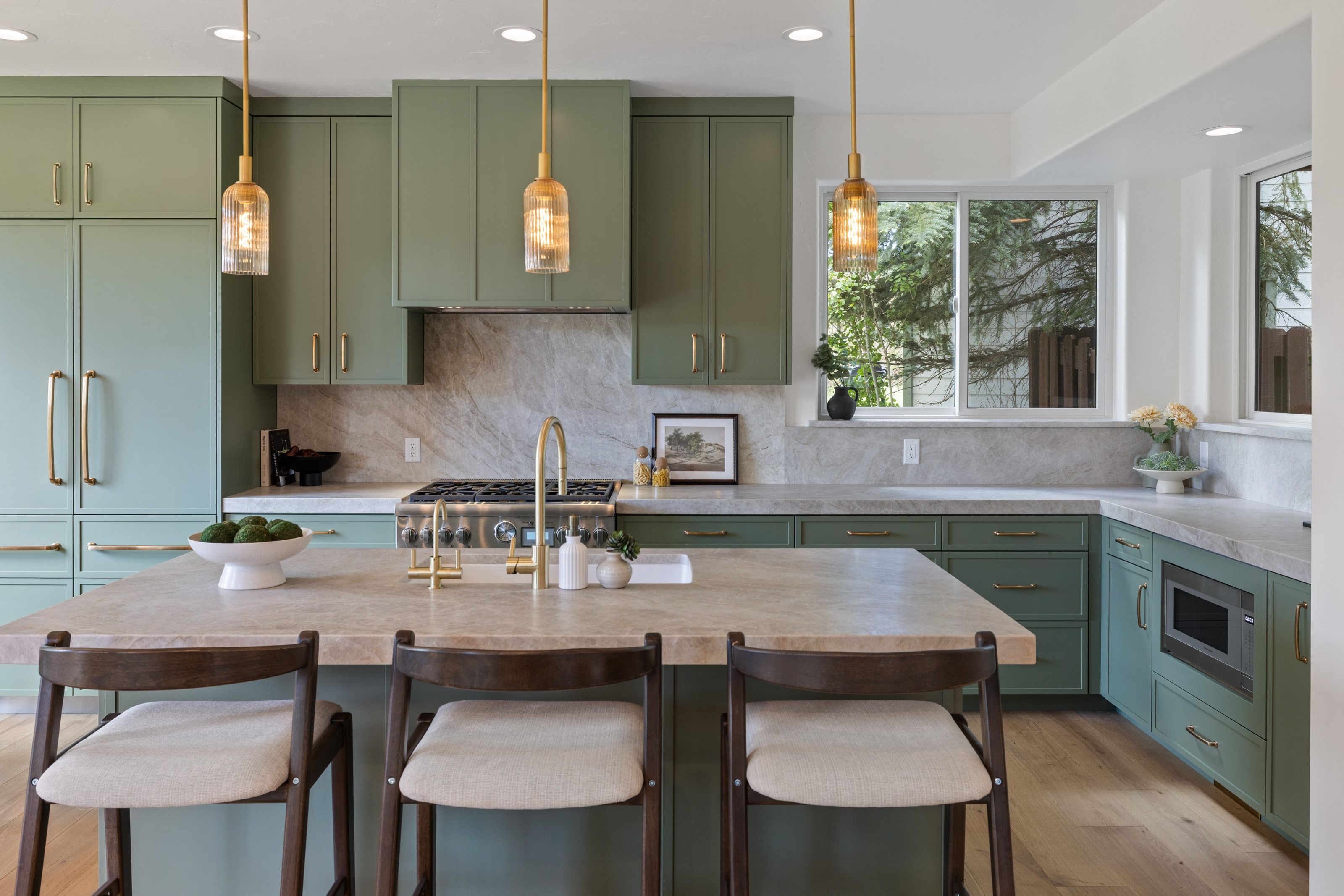 Kitchen featuring sage green cabinetry, a large center island with seating, a stainless steel range, integrated microwave, and wood-finish flooring