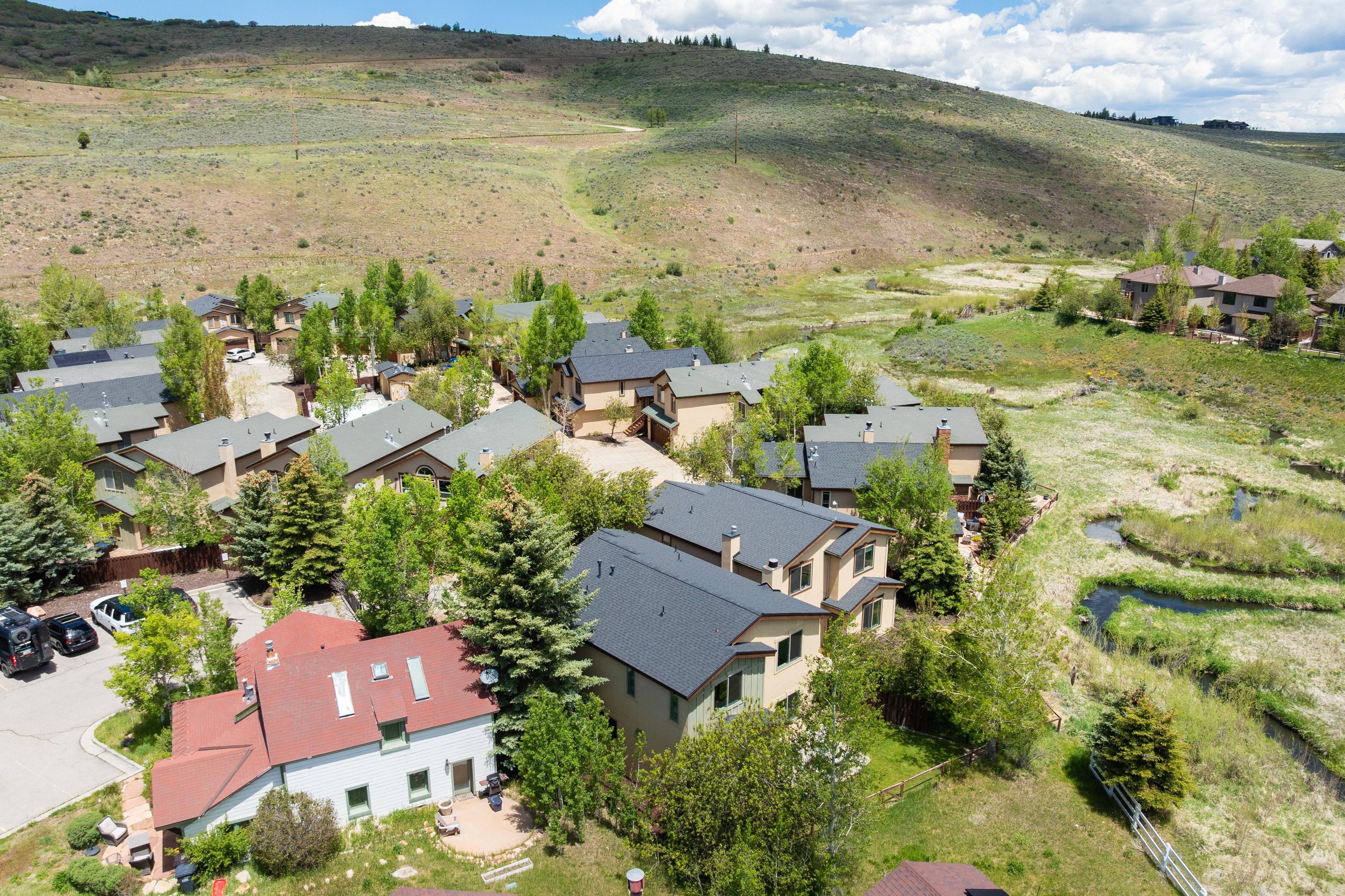 Aerial perspective showcasing a residential community nestled among rolling hills