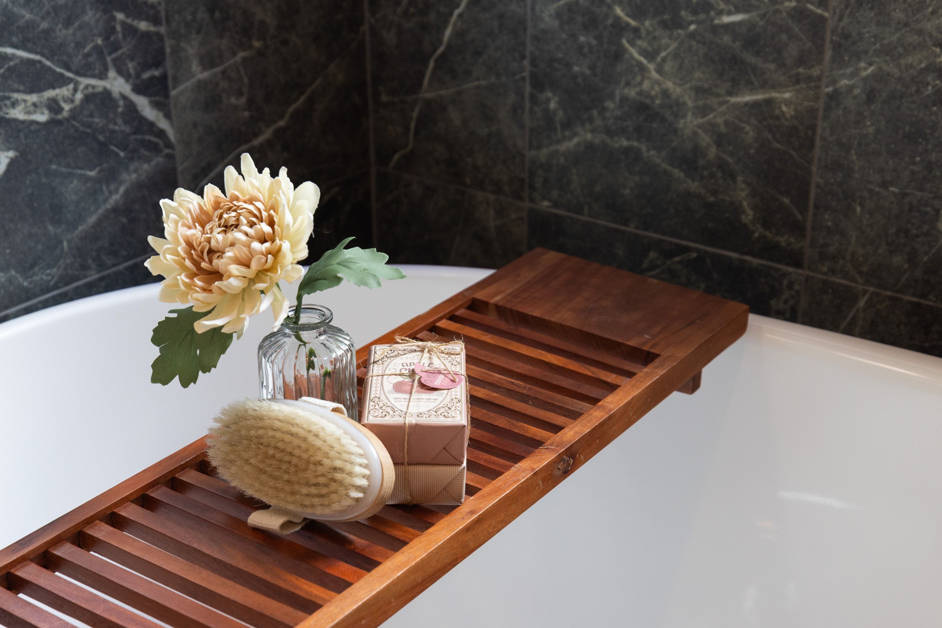 Deep soaking tub with dark stone-finish tiled surround
