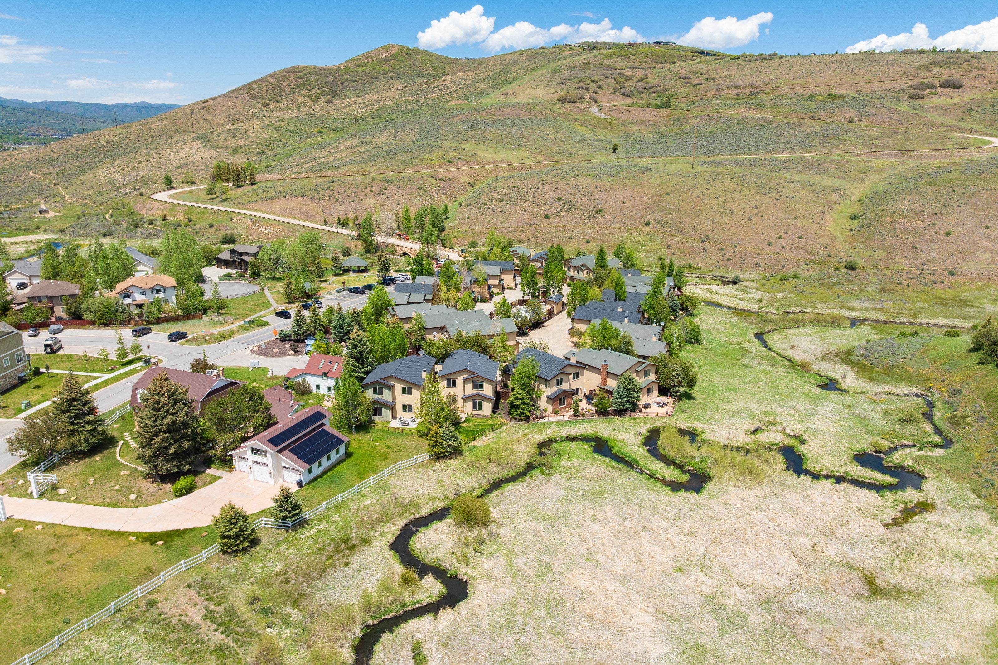 Expansive aerial capturing a neighborhood nestled against a mountainous backdrop