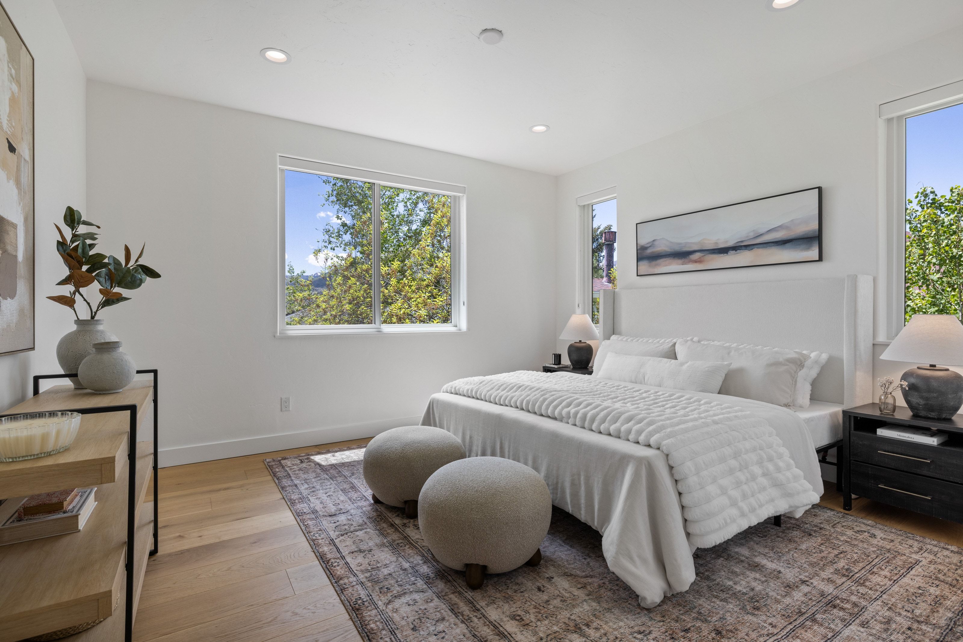 Bedroom featuring light-tone wood-finish flooring, recessed lighting, and multiple windows
