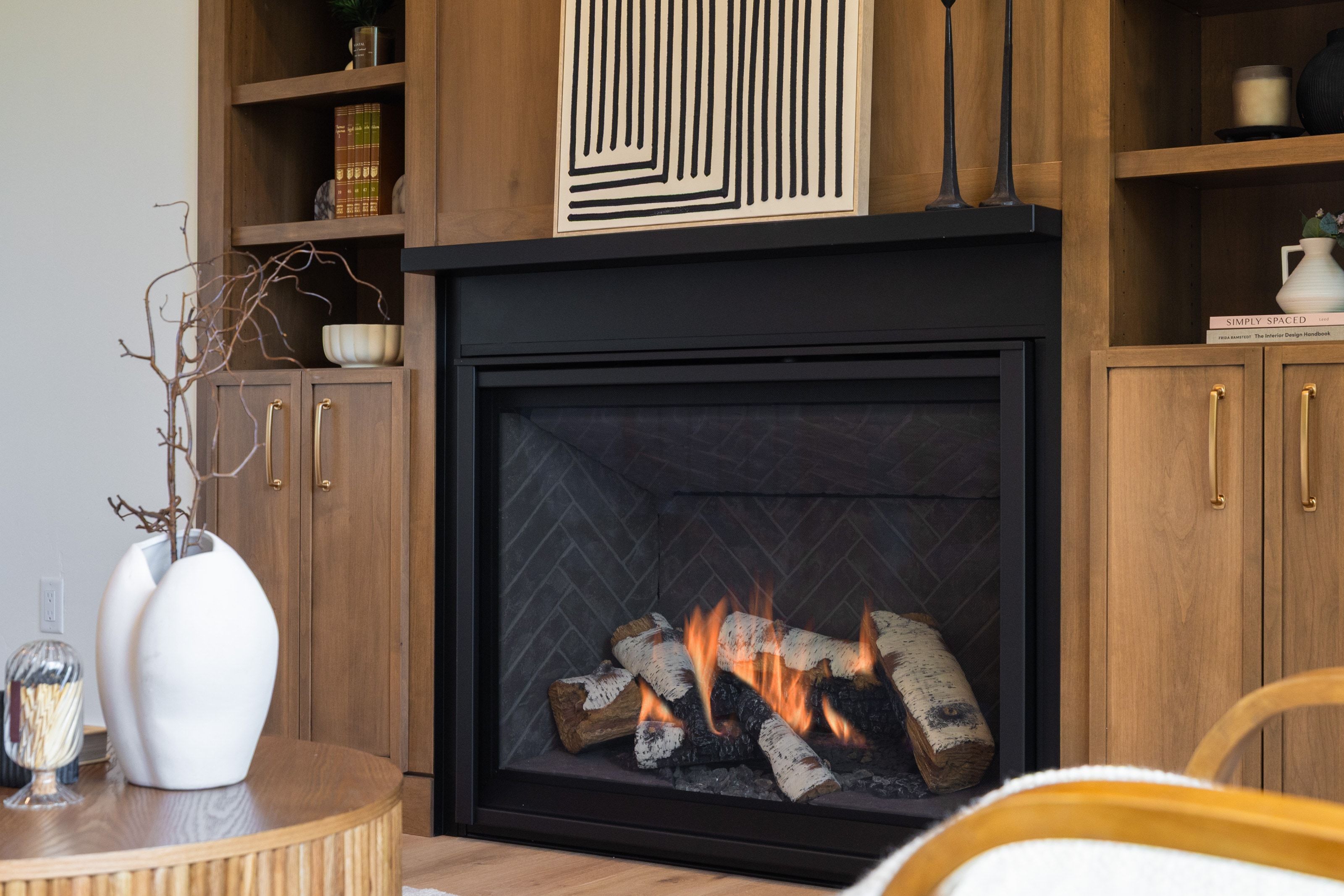 Fireplace with a black surround and herringbone-patterned interior