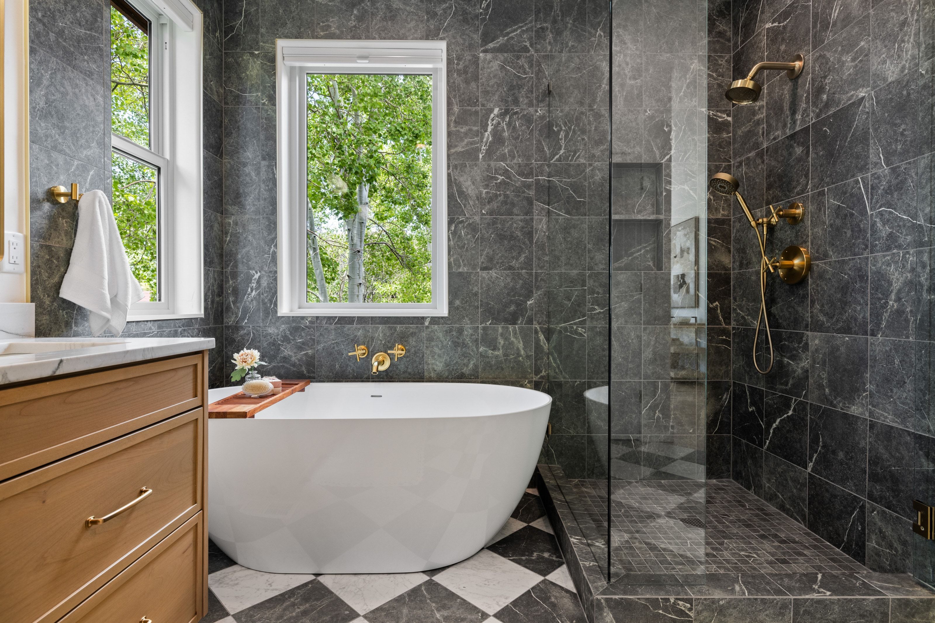 Freestanding soaking tub with gold-finish wall-mounted fixtures