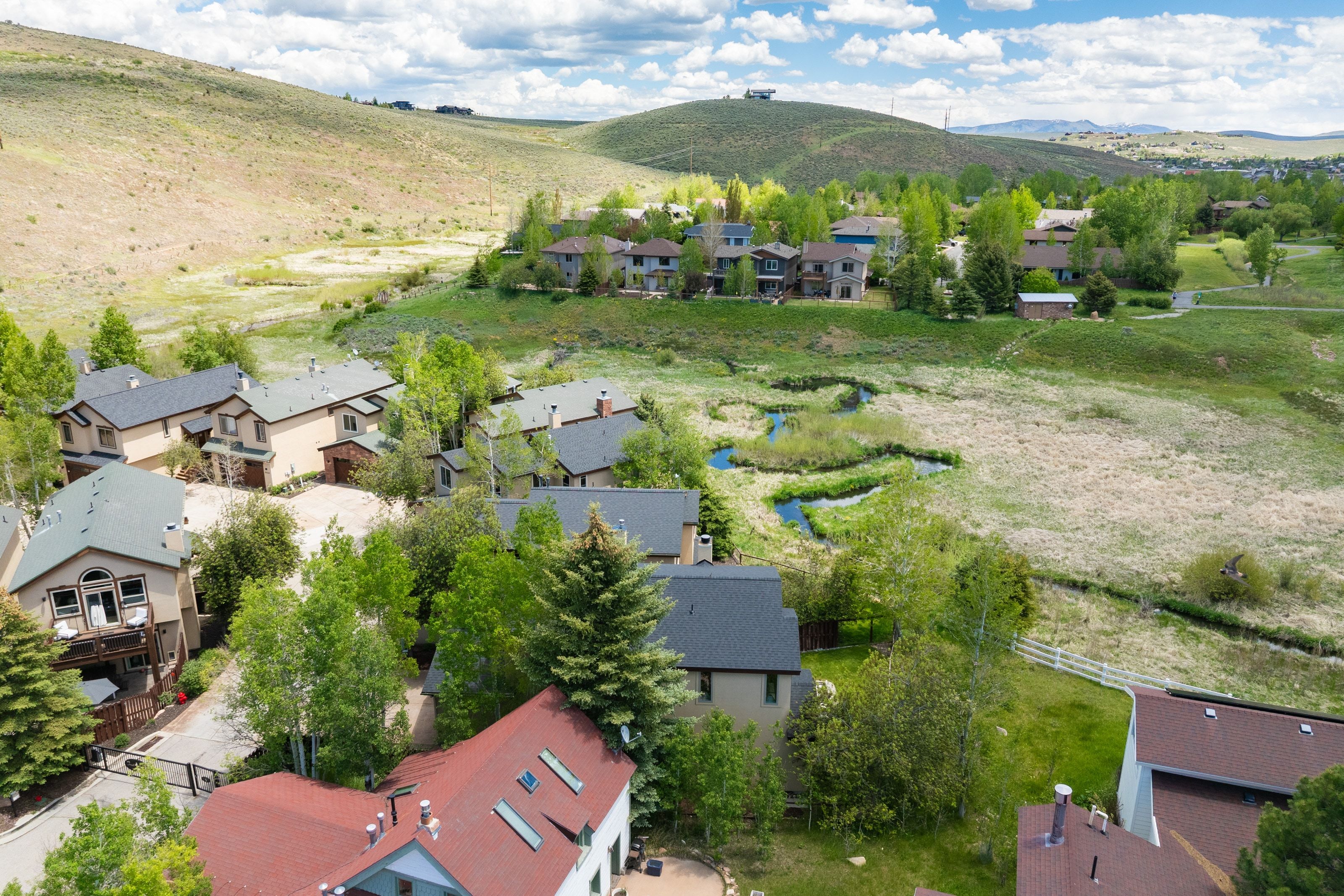 Aerial perspective showcasing a residential community nestled among rolling hills and natural waterways