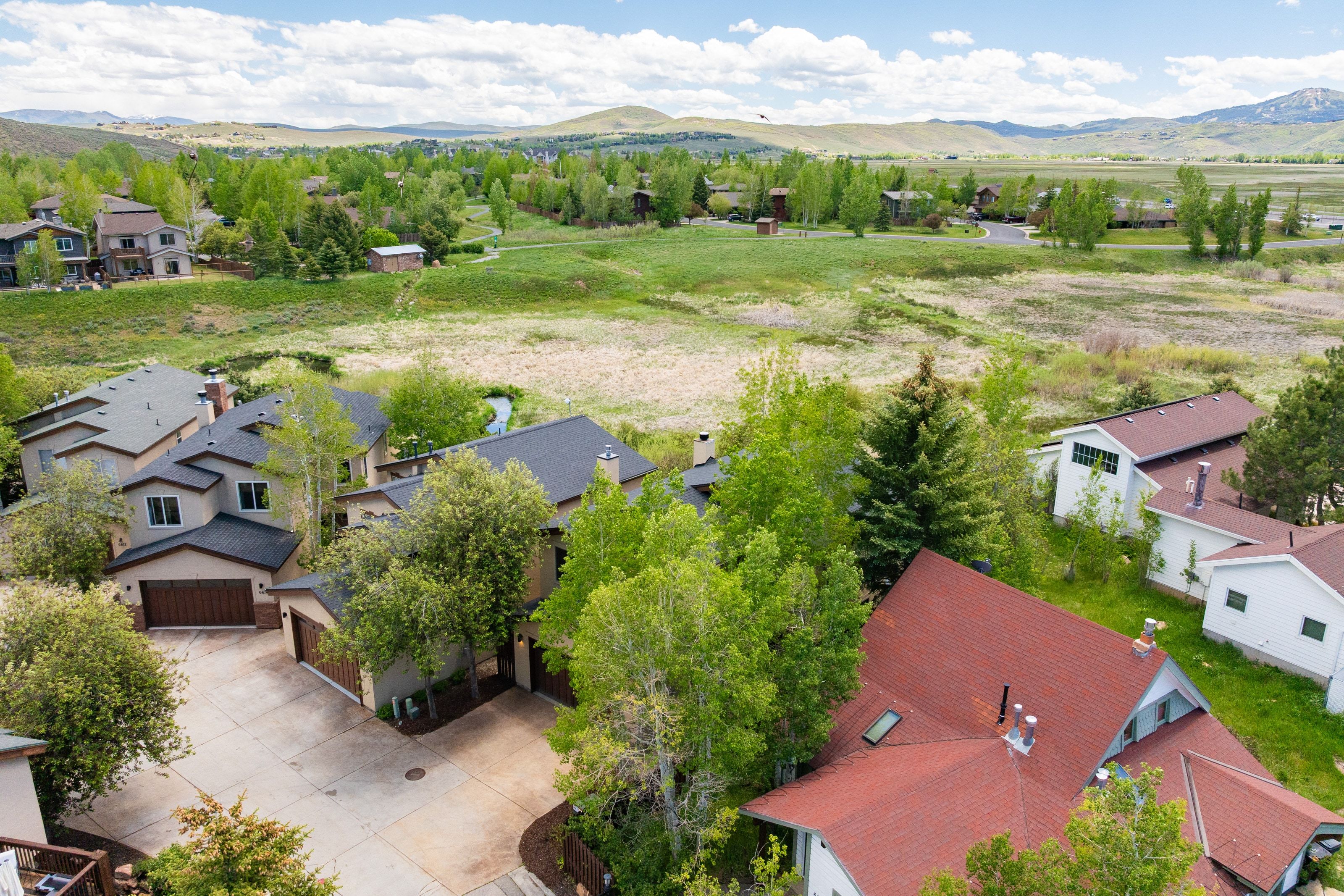Expansive property with multiple structures, including a primary residence featuring a two-car garage and a paved driveway