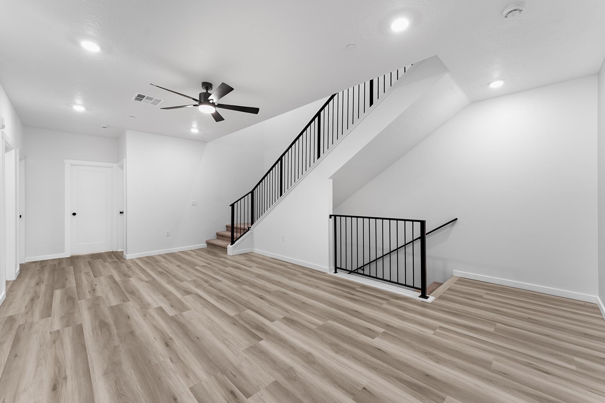 Open living area featuring wood-finish flooring, recessed lighting, and a modern ceiling fan