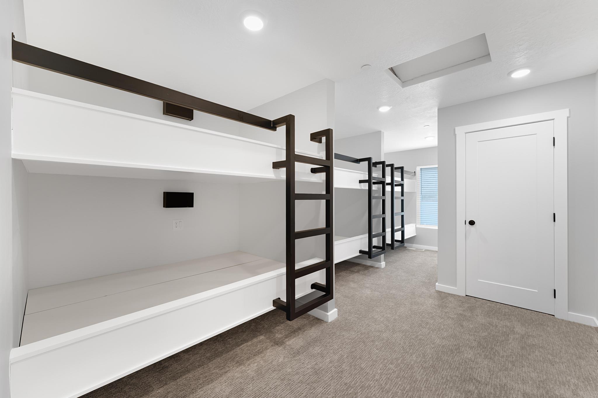 Custom built-in bunk beds with dark metal ladders