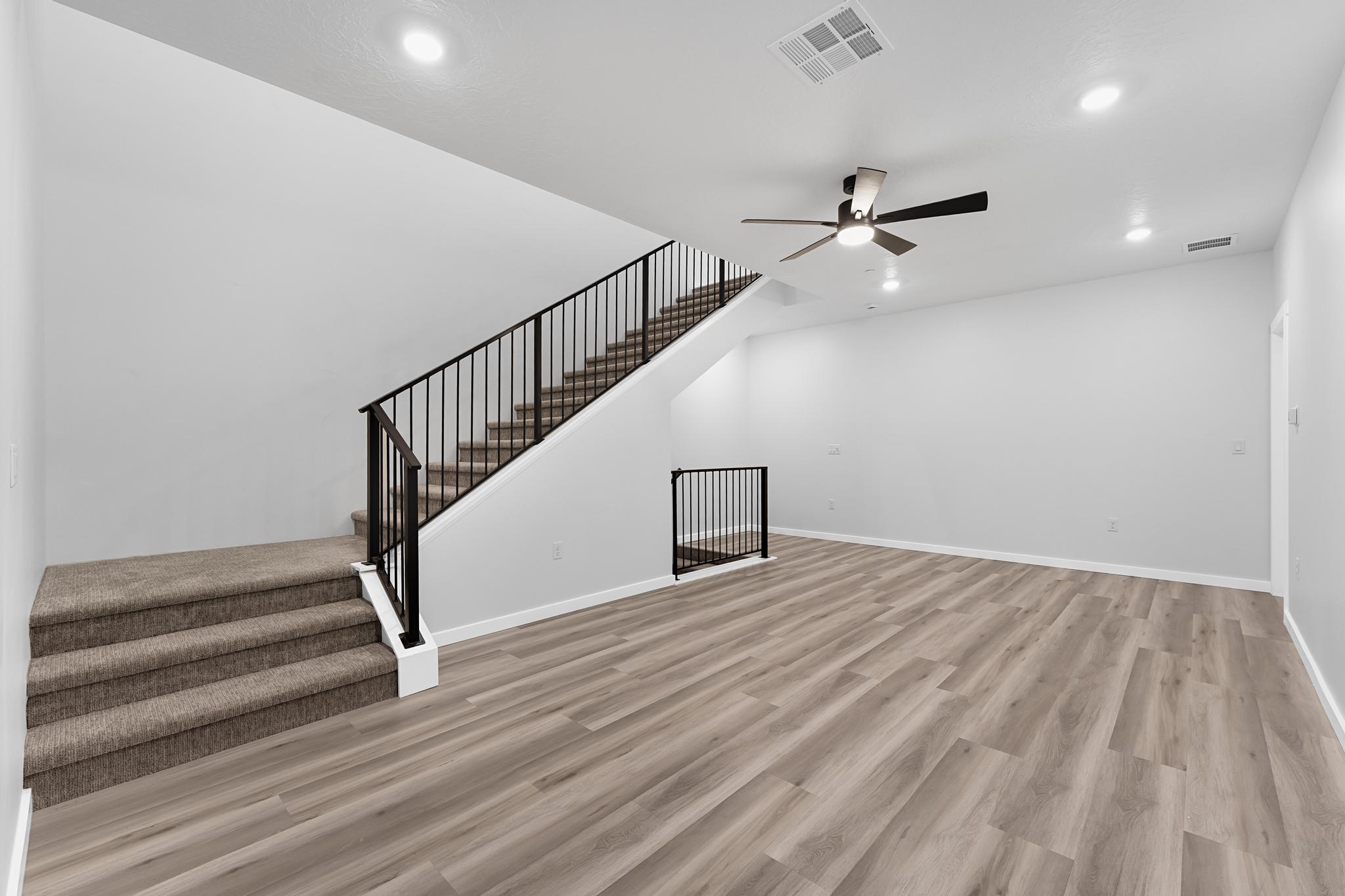 Spacious living area featuring light wood-finish flooring and neutral wall tones