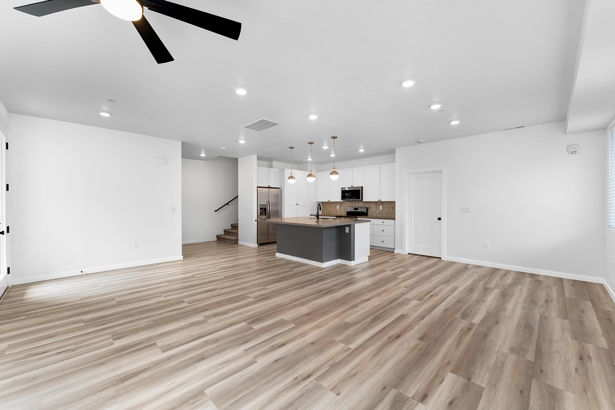 Open-concept living space featuring wood-finish flooring, recessed lighting, and a modern ceiling fan