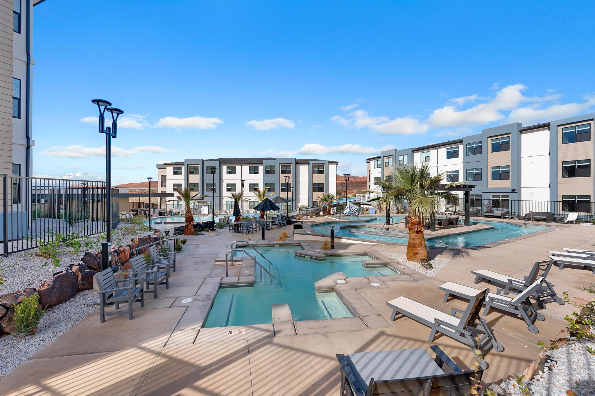 Expansive pool area featuring multiple swimming pools, integrated spas, and a concrete patio surround