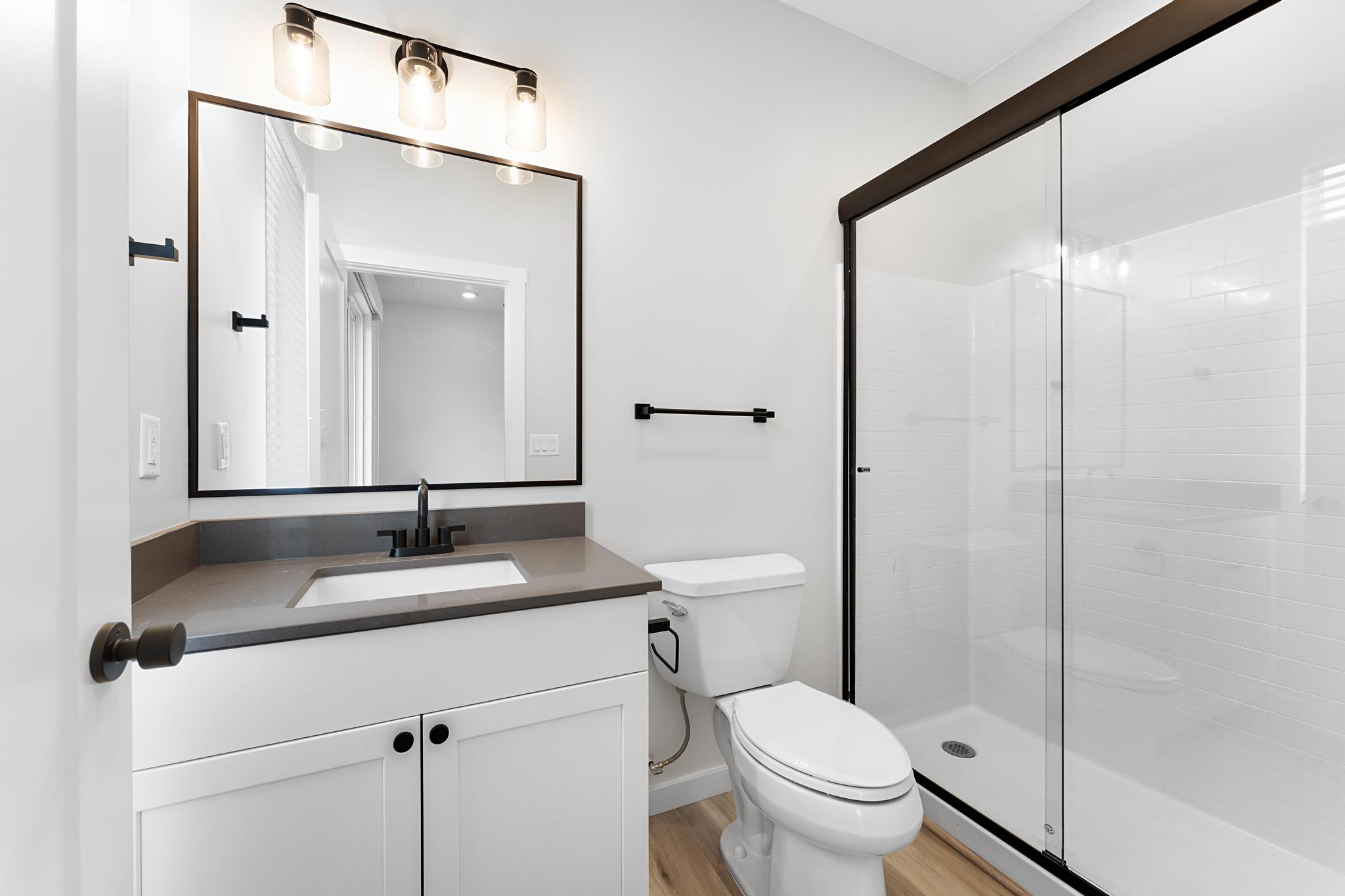 Bathroom featuring a white vanity with a dark countertop, an undermount sink, and matte black fixtures
