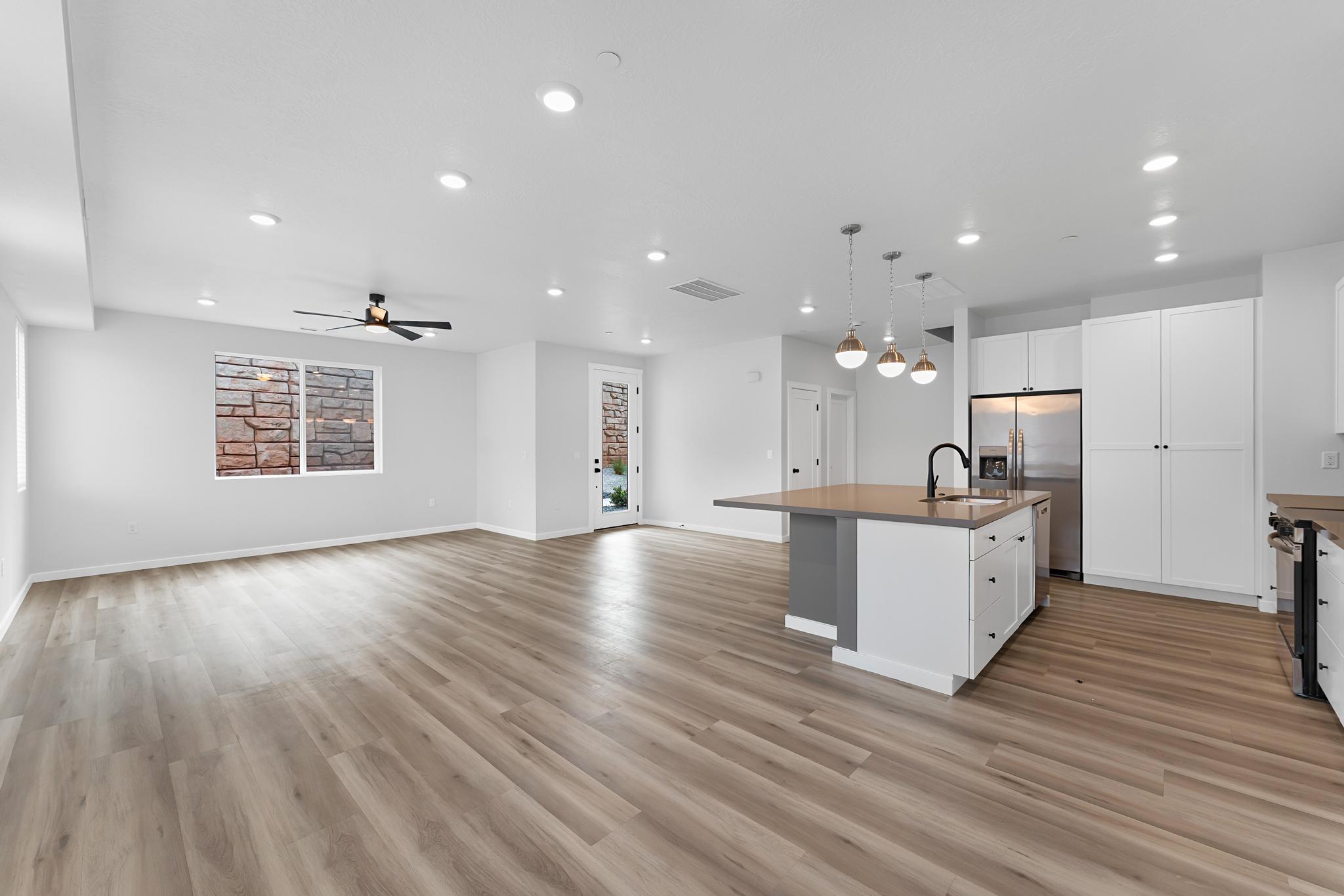 Spacious living area featuring wood-finish flooring, recessed lighting, and a modern ceiling fan