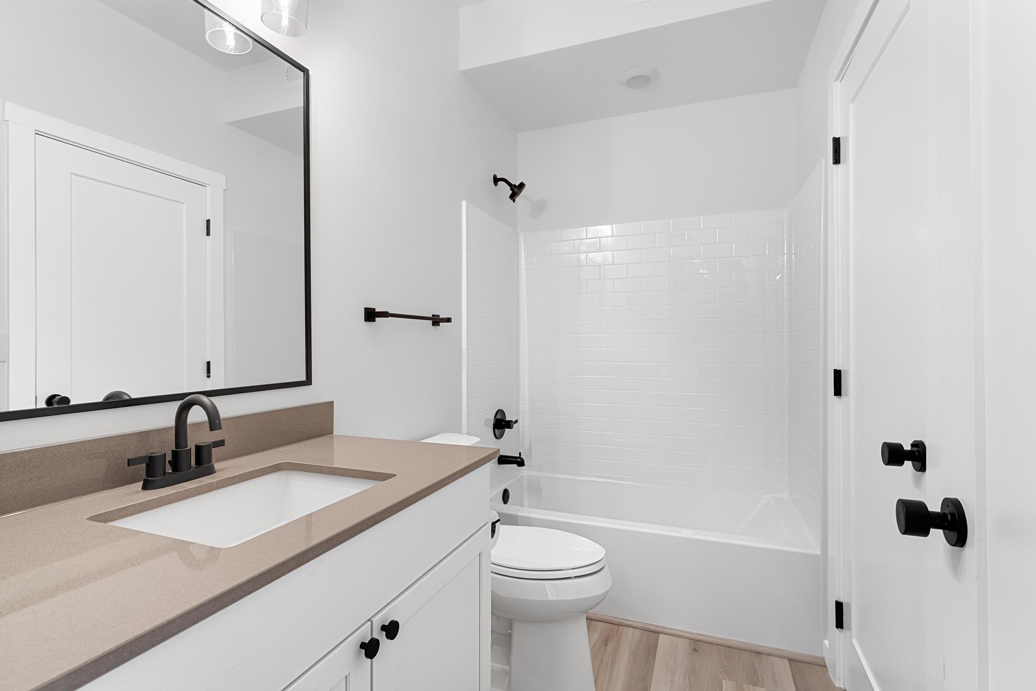 Modern bathroom featuring a single vanity with a neutral-toned countertop and white cabinetry