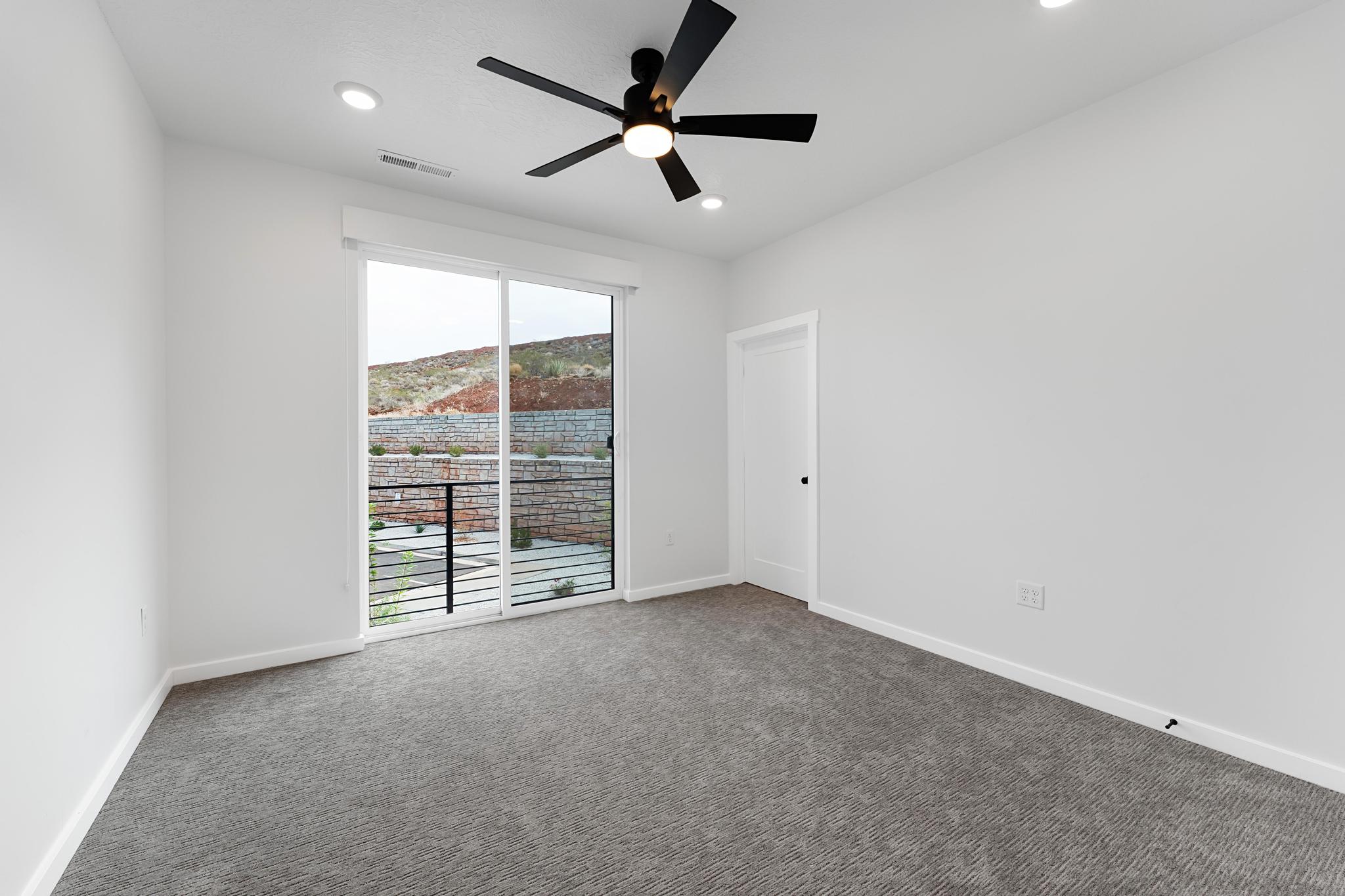Spacious room featuring a glass sliding door, recessed lighting, and a modern ceiling fan