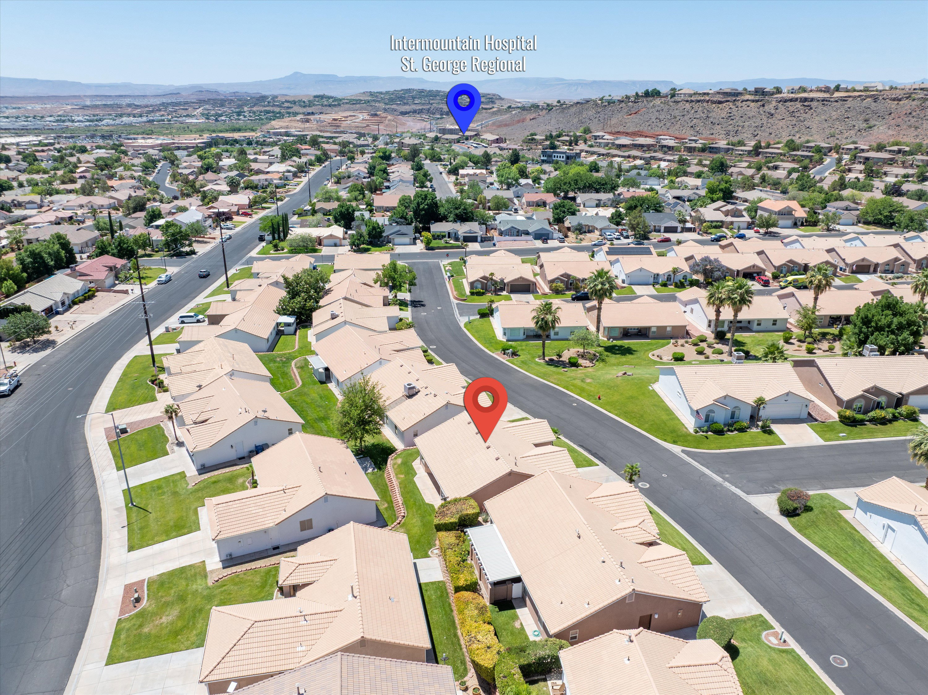 Aerial view showcasing a residential neighborhood with single-story homes, paved streets, and green lawns