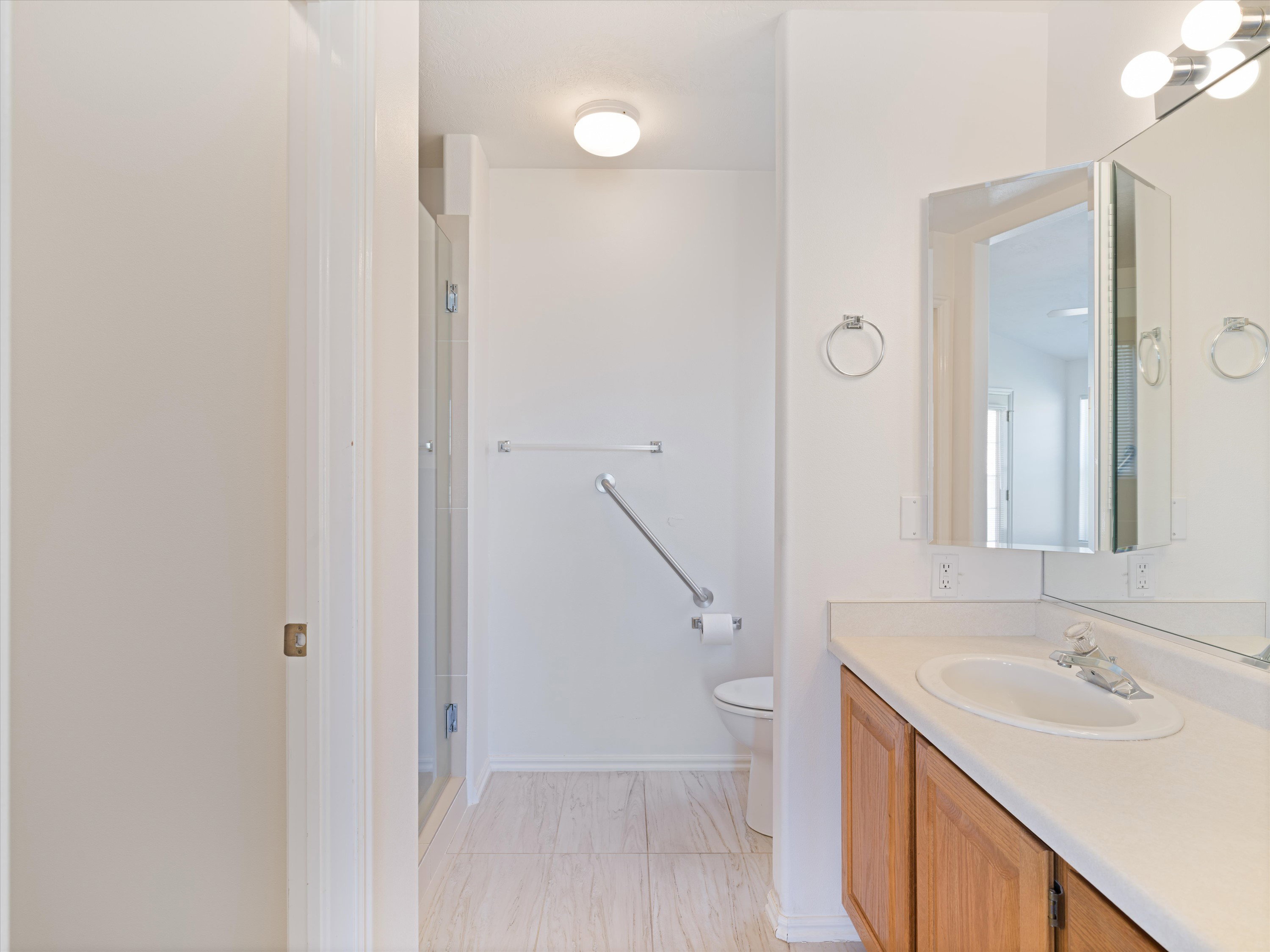 Bathroom featuring a wood-finish vanity with an integrated sink and laminate countertop