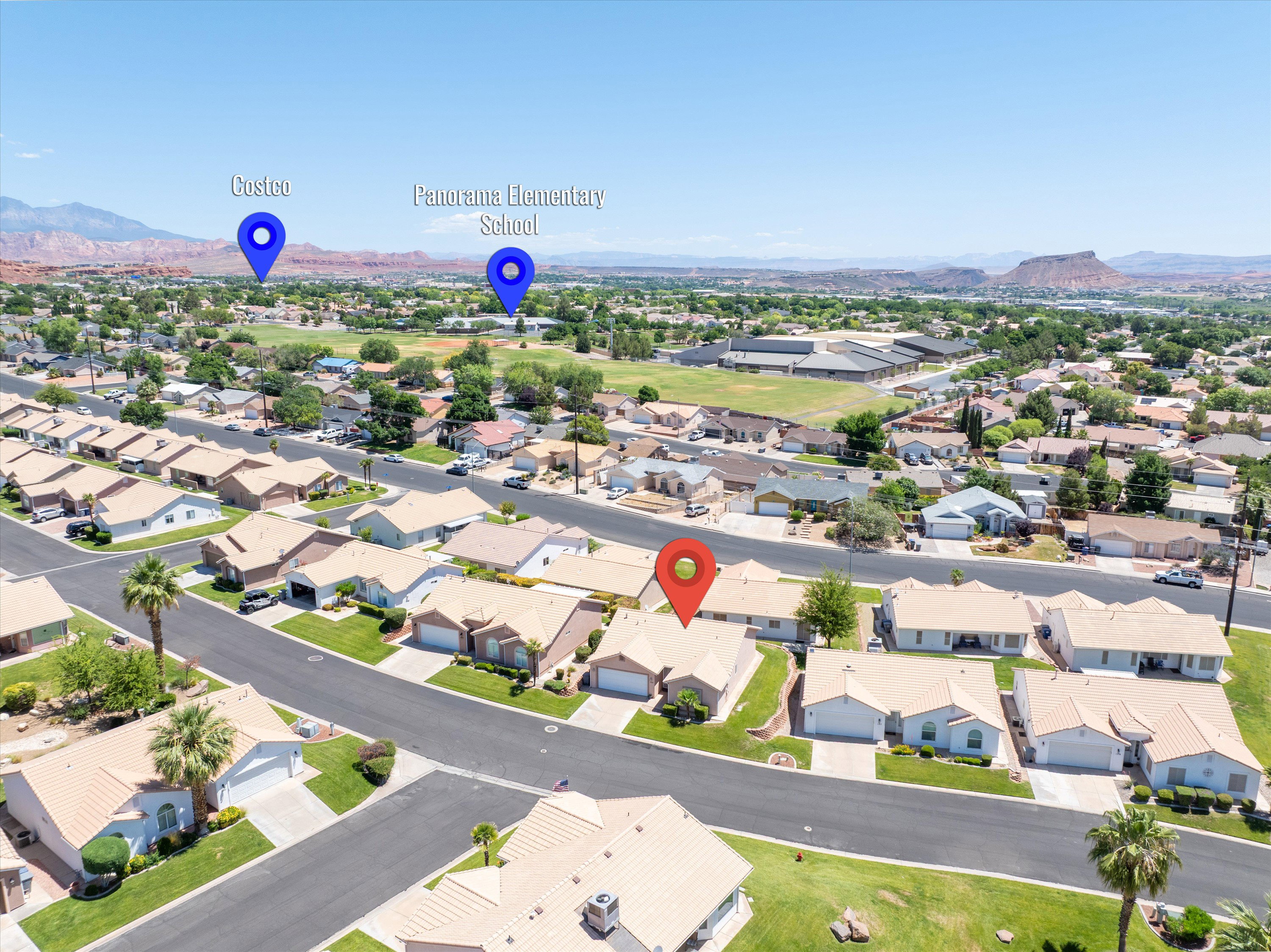 Aerial perspective showcasing a residential neighborhood with single-story homes, surrounded by natural desert landscaping and distant mountains